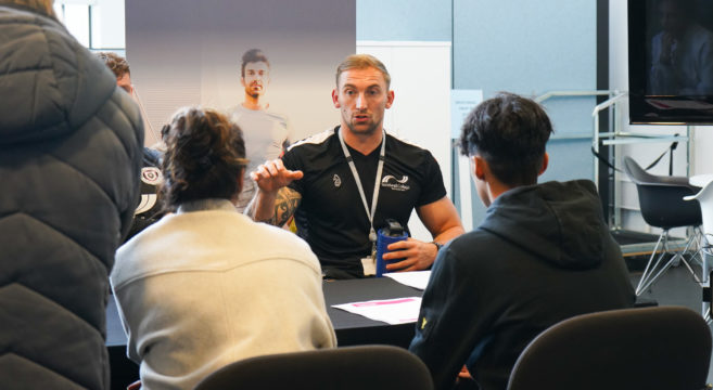 Sports teacher talking to prospective students