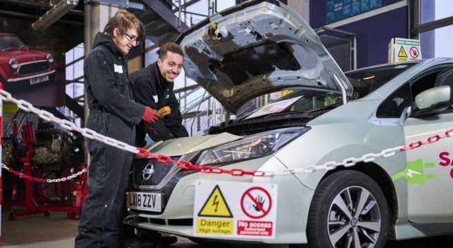 Two male students working on an electric vehicle